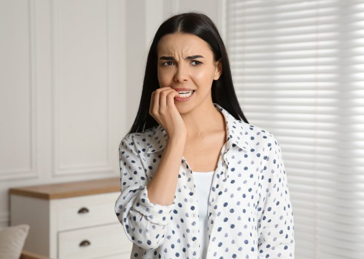 ragazza preoccupata con le dita tra i denti
