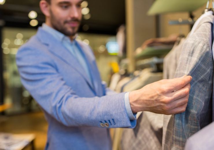 uomo che guarda degli abiti
