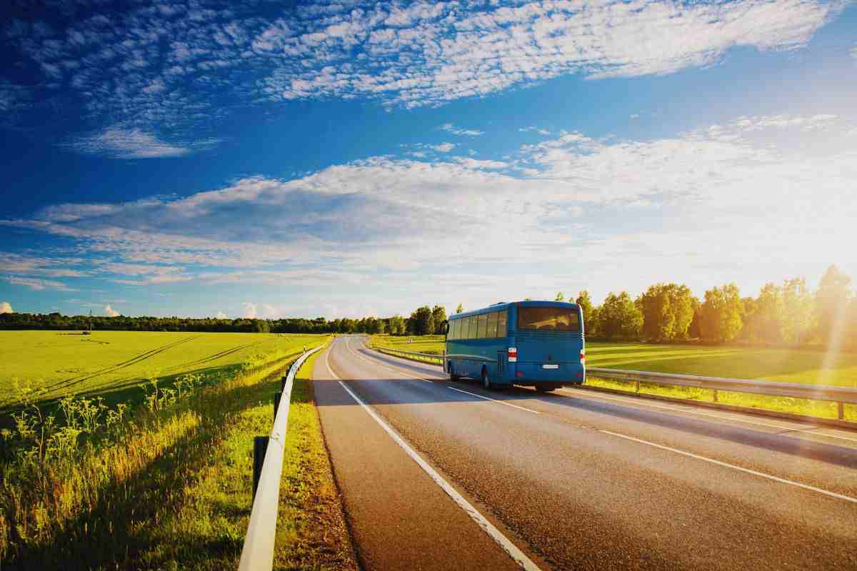 Autobus percorre una strada baciata dal sole
