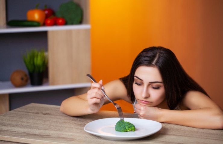 Donna a dieta con verdura nel piatto