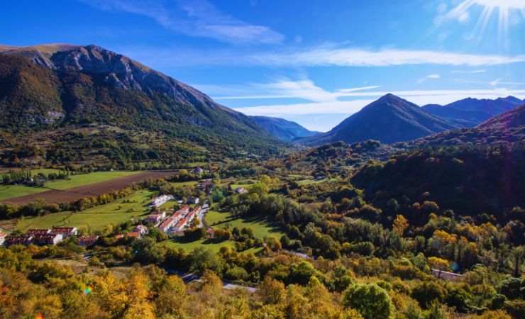 un paesaggio con distesa verde e montagne