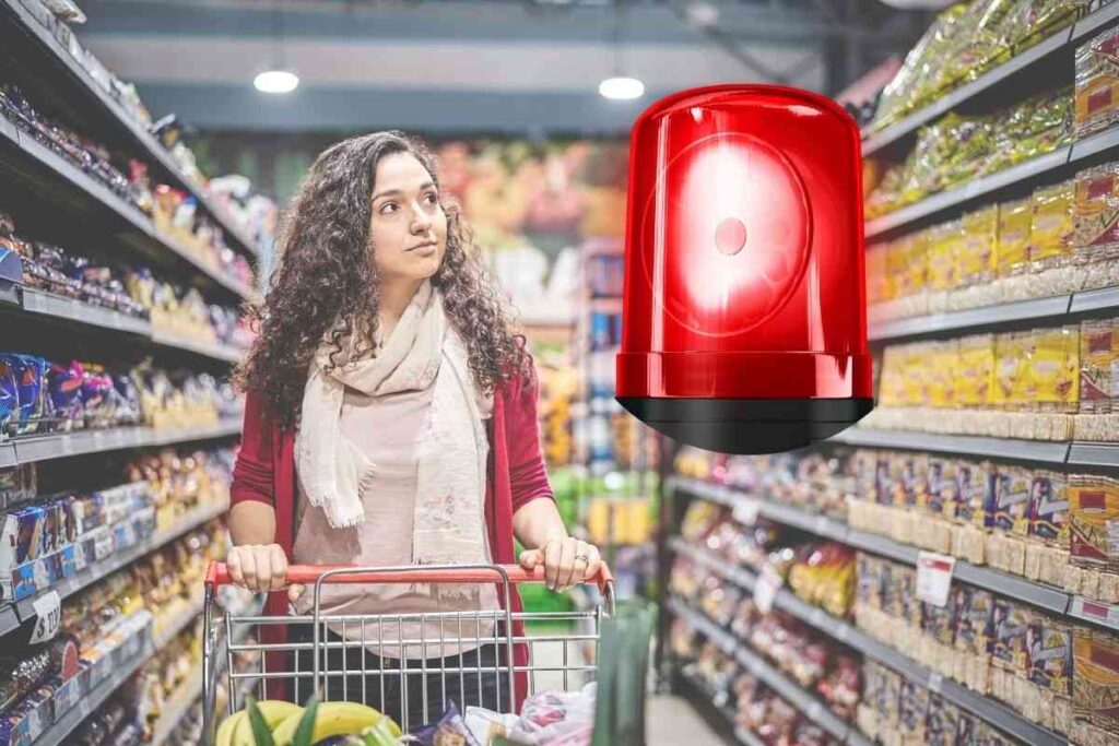 ragazza nelle corsie di un supermercato e una sirena