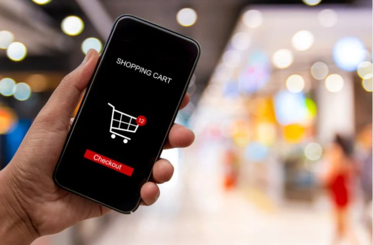 mano con smartphone e icona carrello