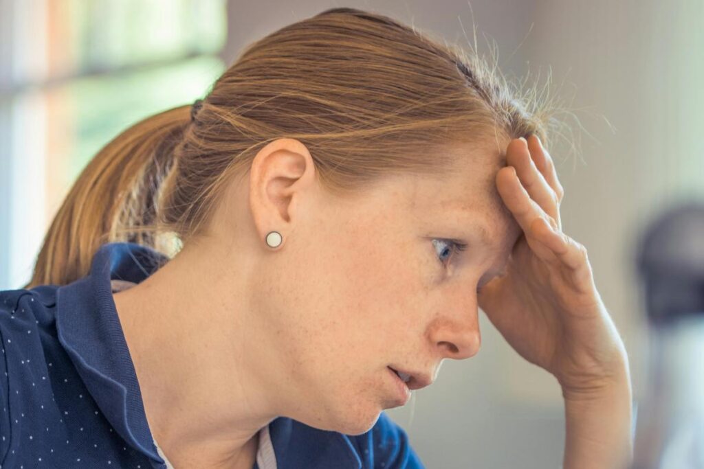 donna preoccupata con una mano sulla fronte