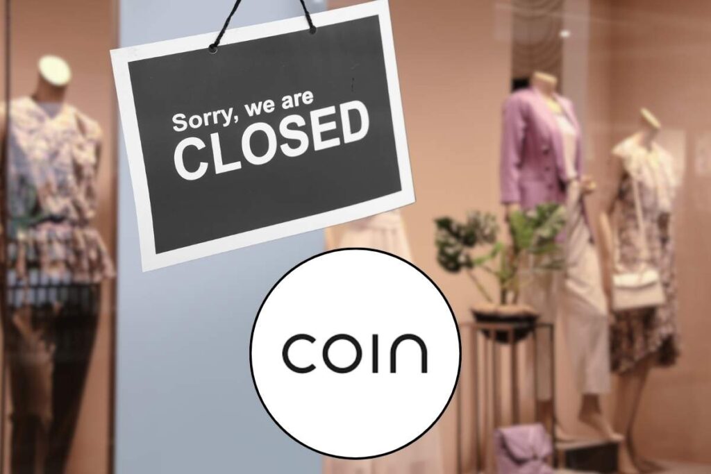 Vetrina di un negozio, cartello chiusura e logo Coin