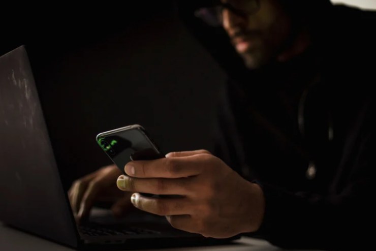 hacker con smartphone e cellulare