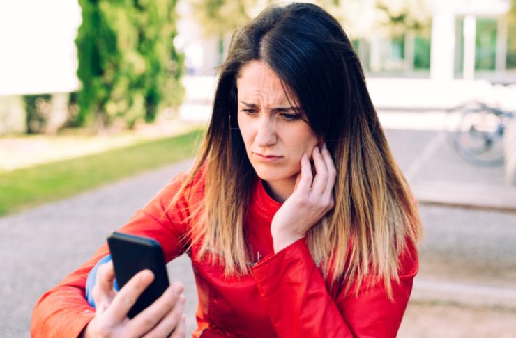 donna preoccupata con smartphone per strada