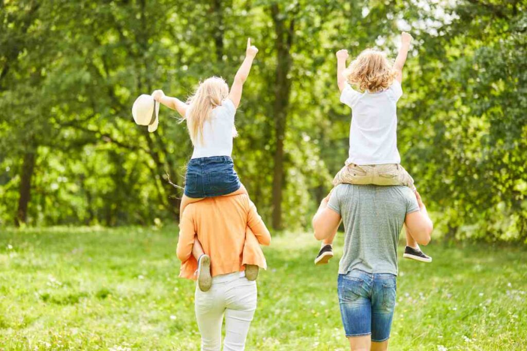 genitori portano in spalla in bambini nella natura in Abruzzo