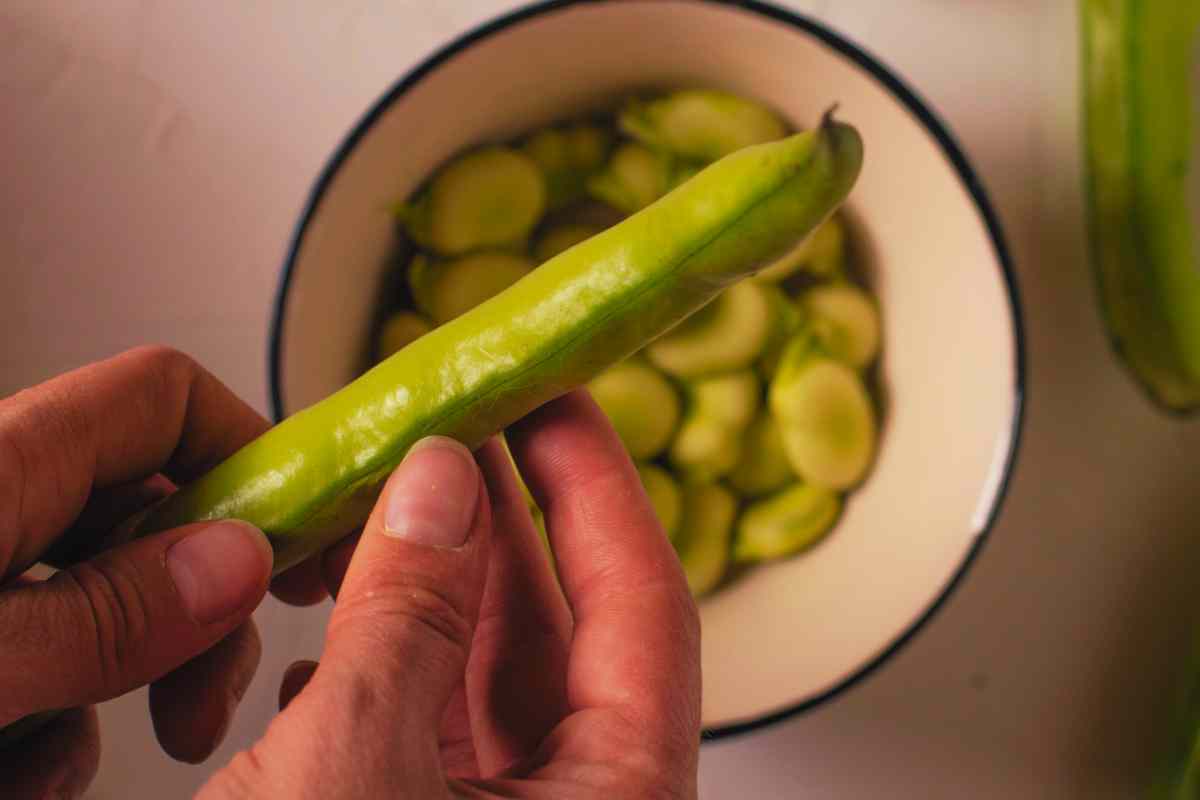 nonna sbuccia le fave per condirci le sagne