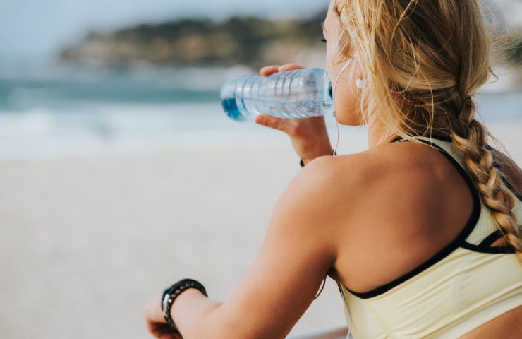 donna in riva al mare che beve