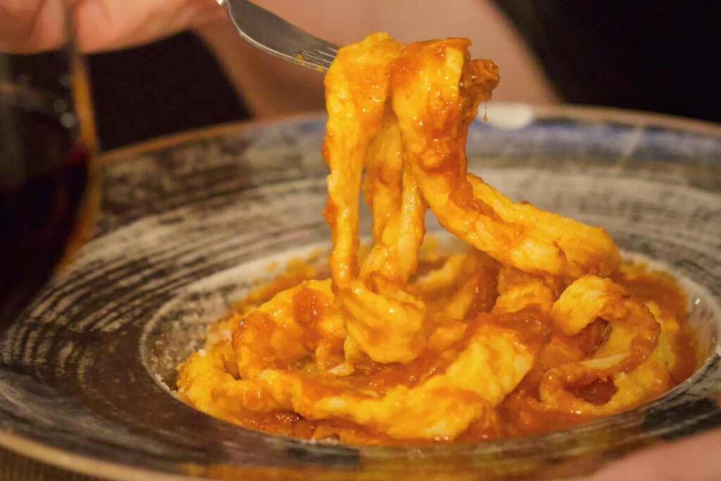 Pasta alla mugnaia in un piatto infilzata con la forchetta
