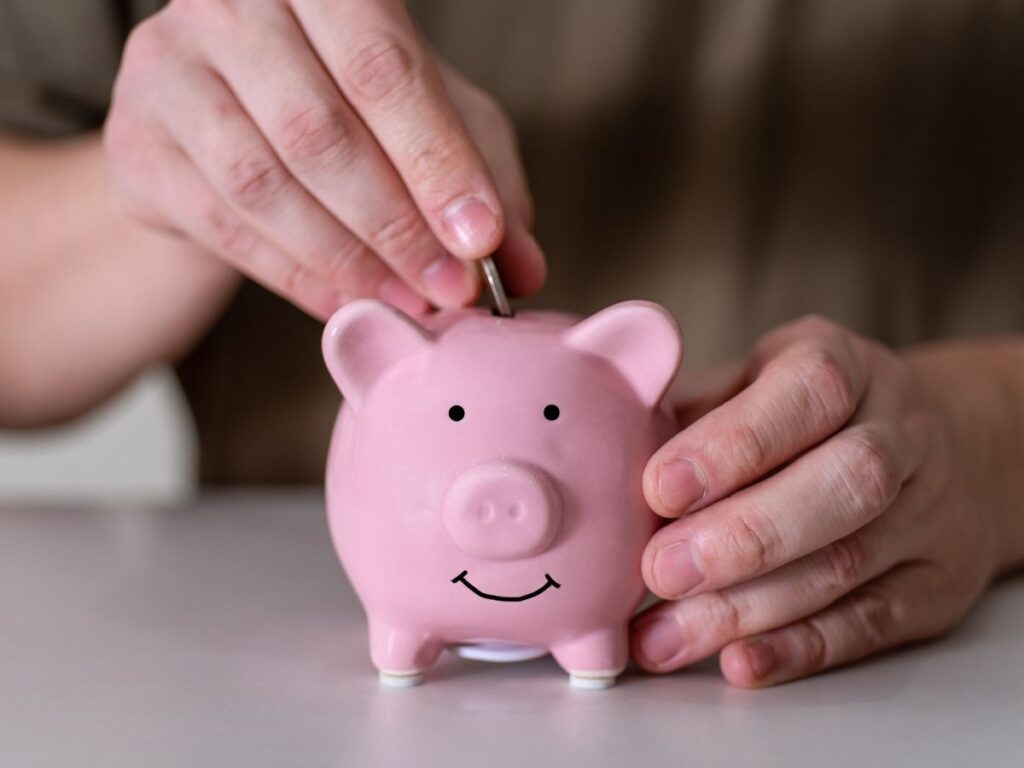 Uomo mette moneta salvadanaio