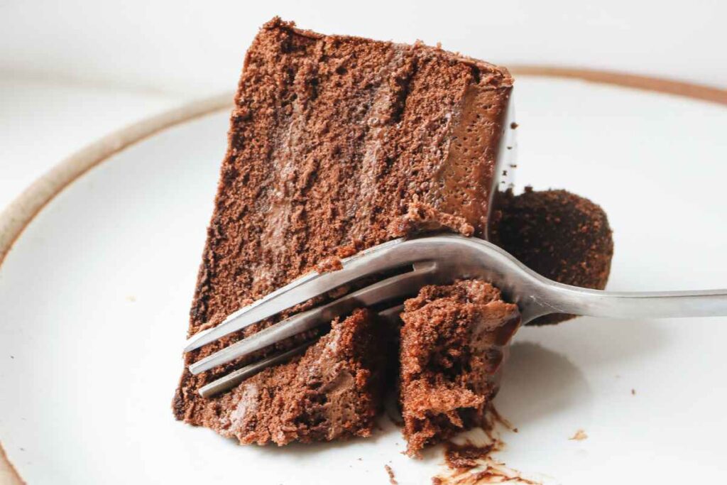 Una fetta di torta del lupo in un piatto con una forchetta che la taglia