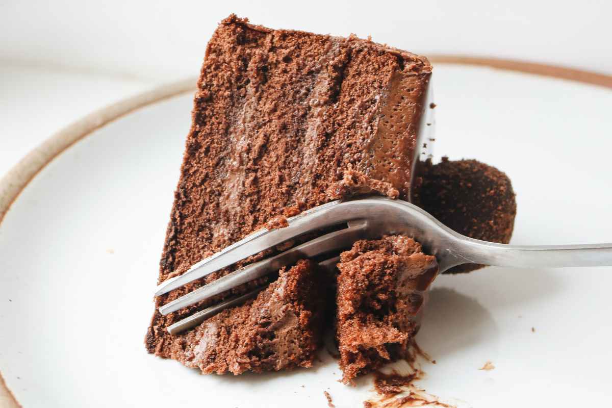 Una fetta di torta del lupo in un piatto con una forchetta che la taglia