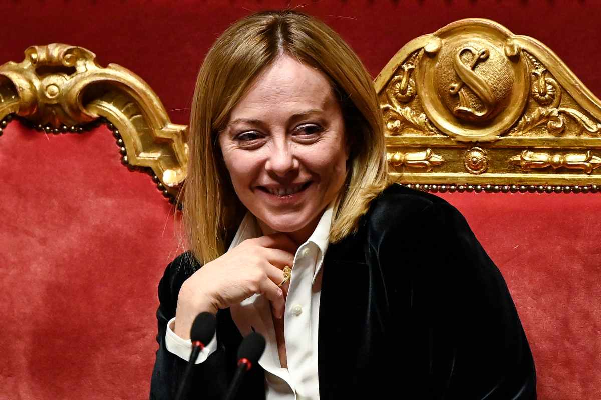 il premier giorgia meloni che sorride seduta in Parlamento
