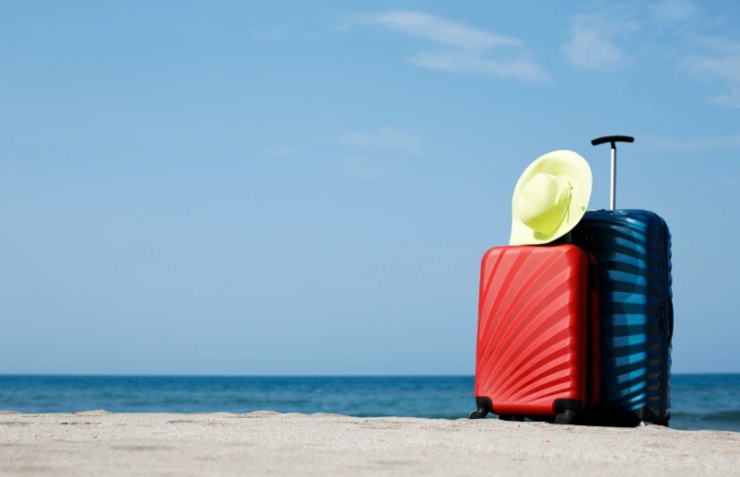 due trolley con sopra un cappello di paglia sulla spiaggia