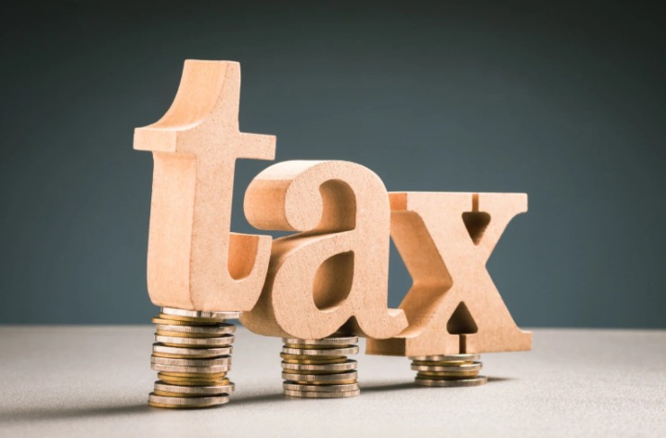 scritta "tasse" sopra pile di monete