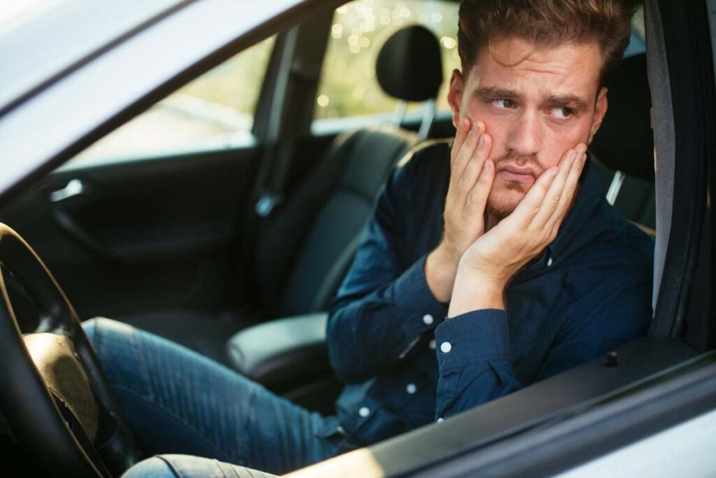uomo in auto preoccupato