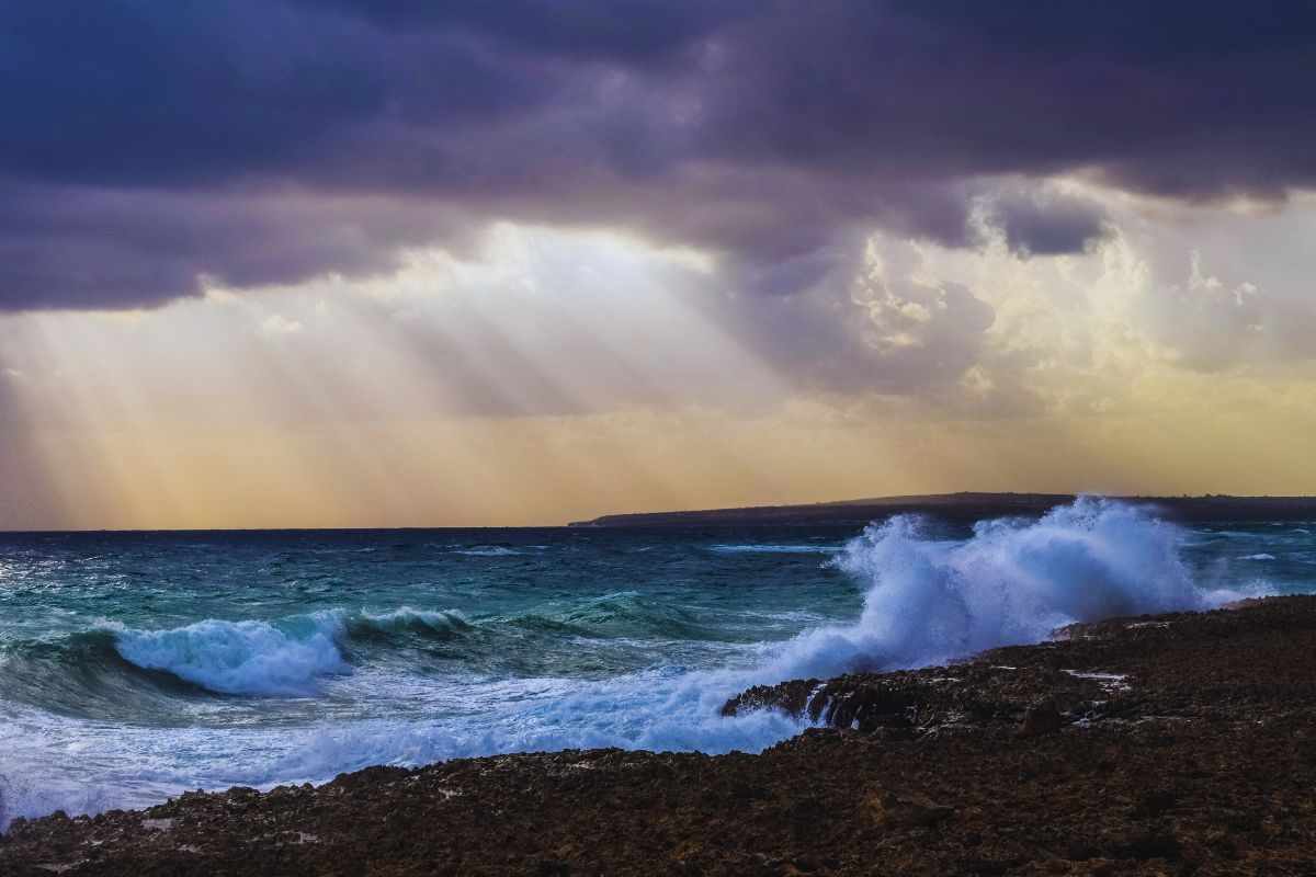 Nuvole minacciose e onde che s'infrangono sugli scogli