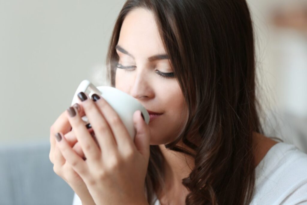 donna con in mano una tazzina di caffè