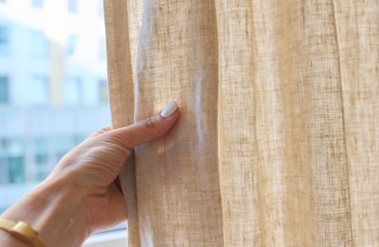 mano che tocca tessuto di una tenda