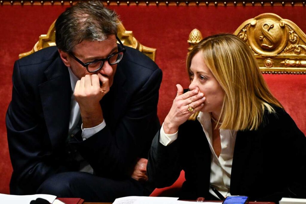 giorgia meloni che parla con il ministro dell'economia giancarlo giorgetti in Parlamento