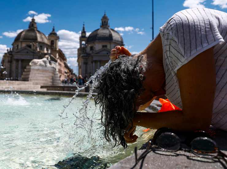 Una persona si bagna la testa per il caldo