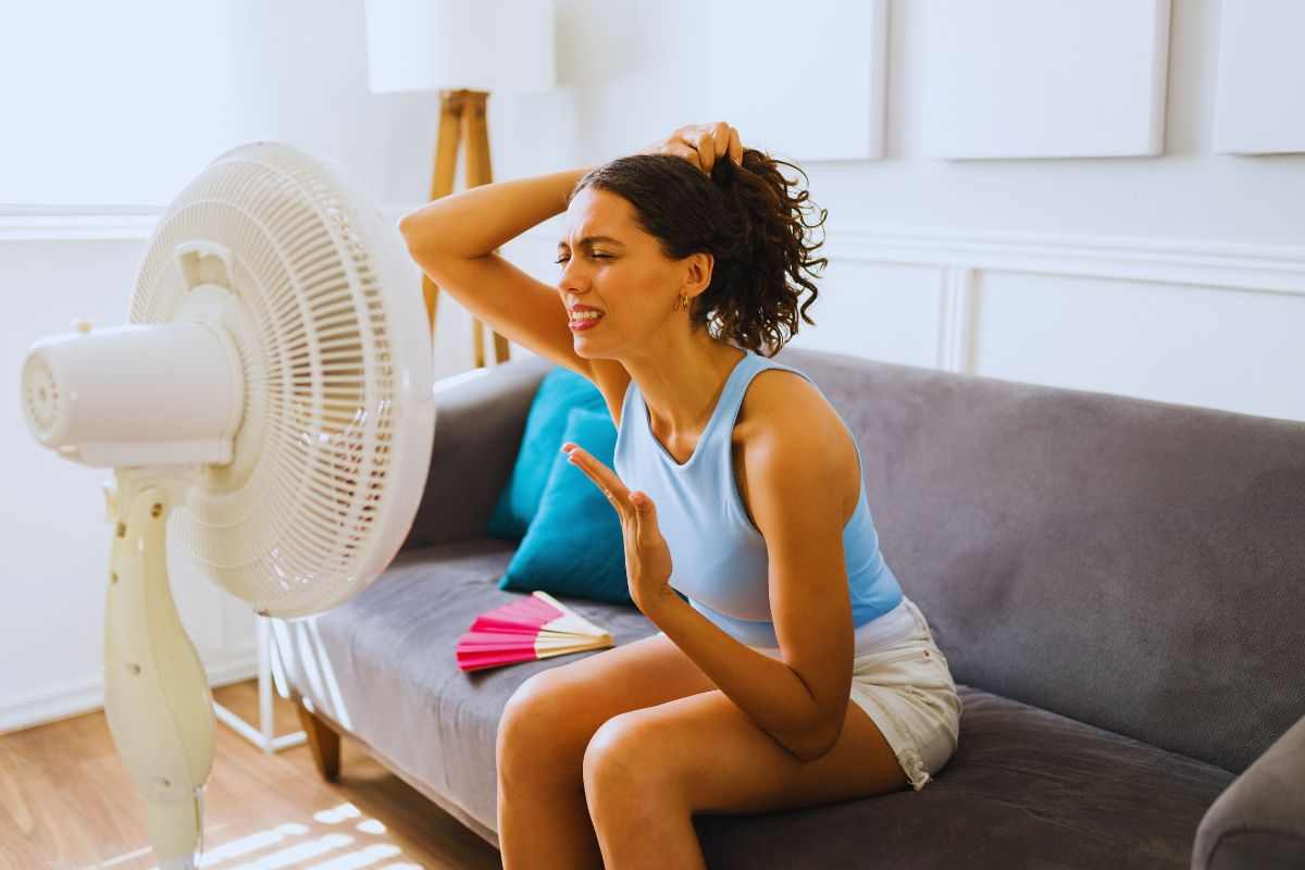 Donna accaldata cerca refrigerio davanti al ventilatore
