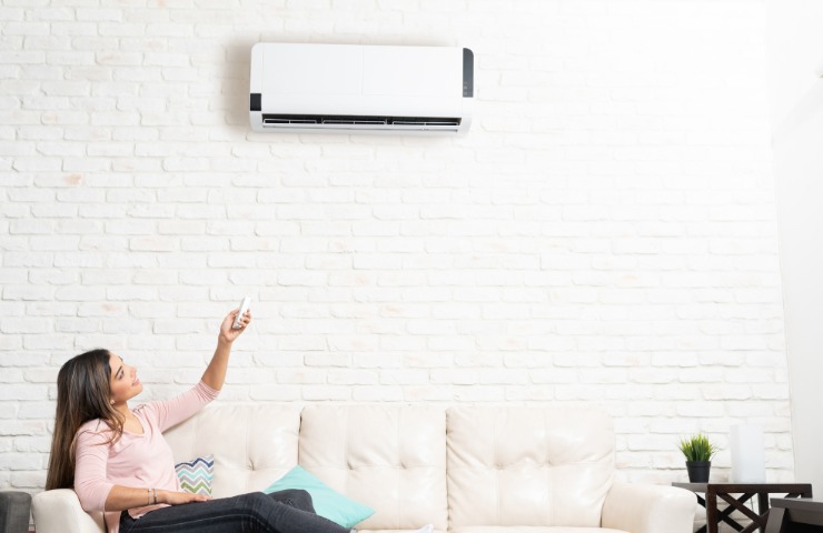 Una donna che accende il condizionatore