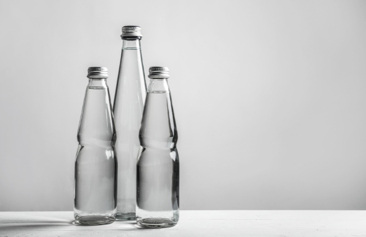 Tre bottiglie di acqua in vetro