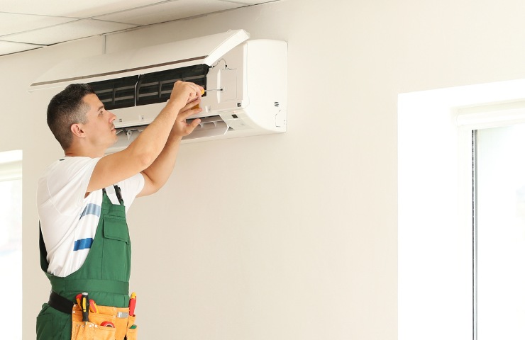 uomo che lavora su di un condizionatore