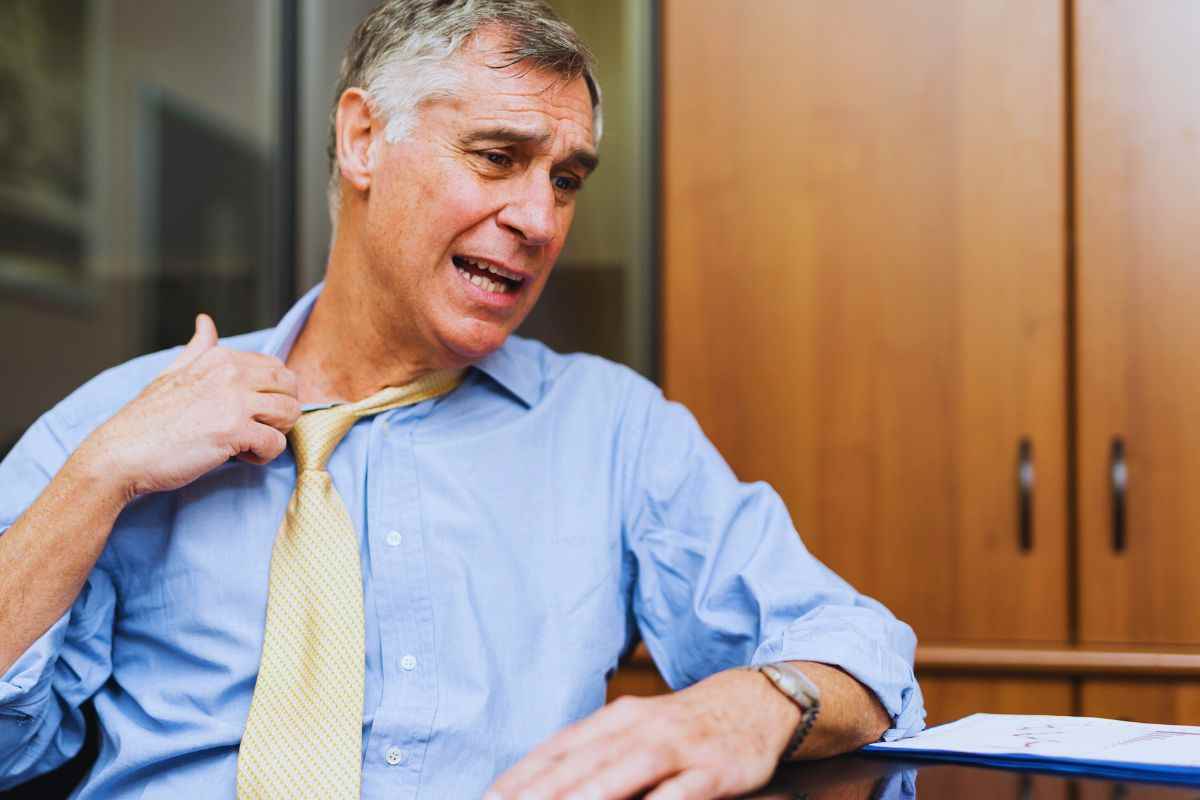 Uomo che allenta la cravatta per il caldo