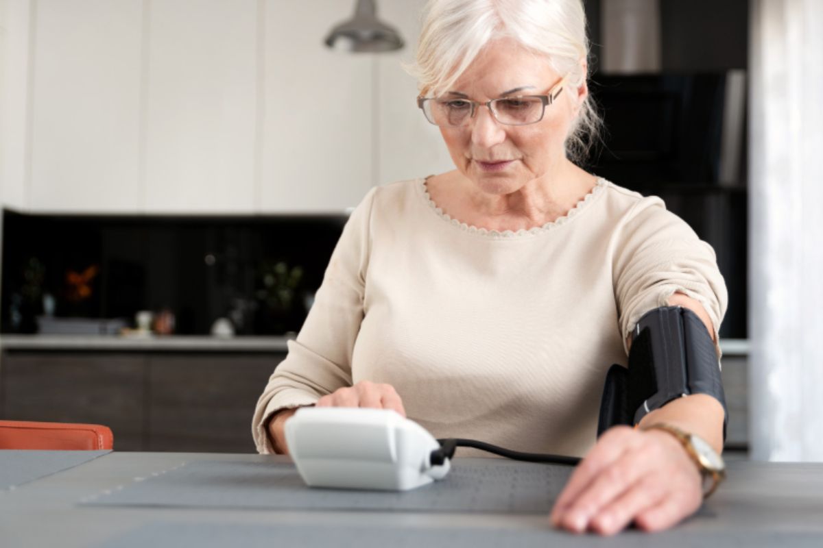 donna seduta che si misura da sola la pressione