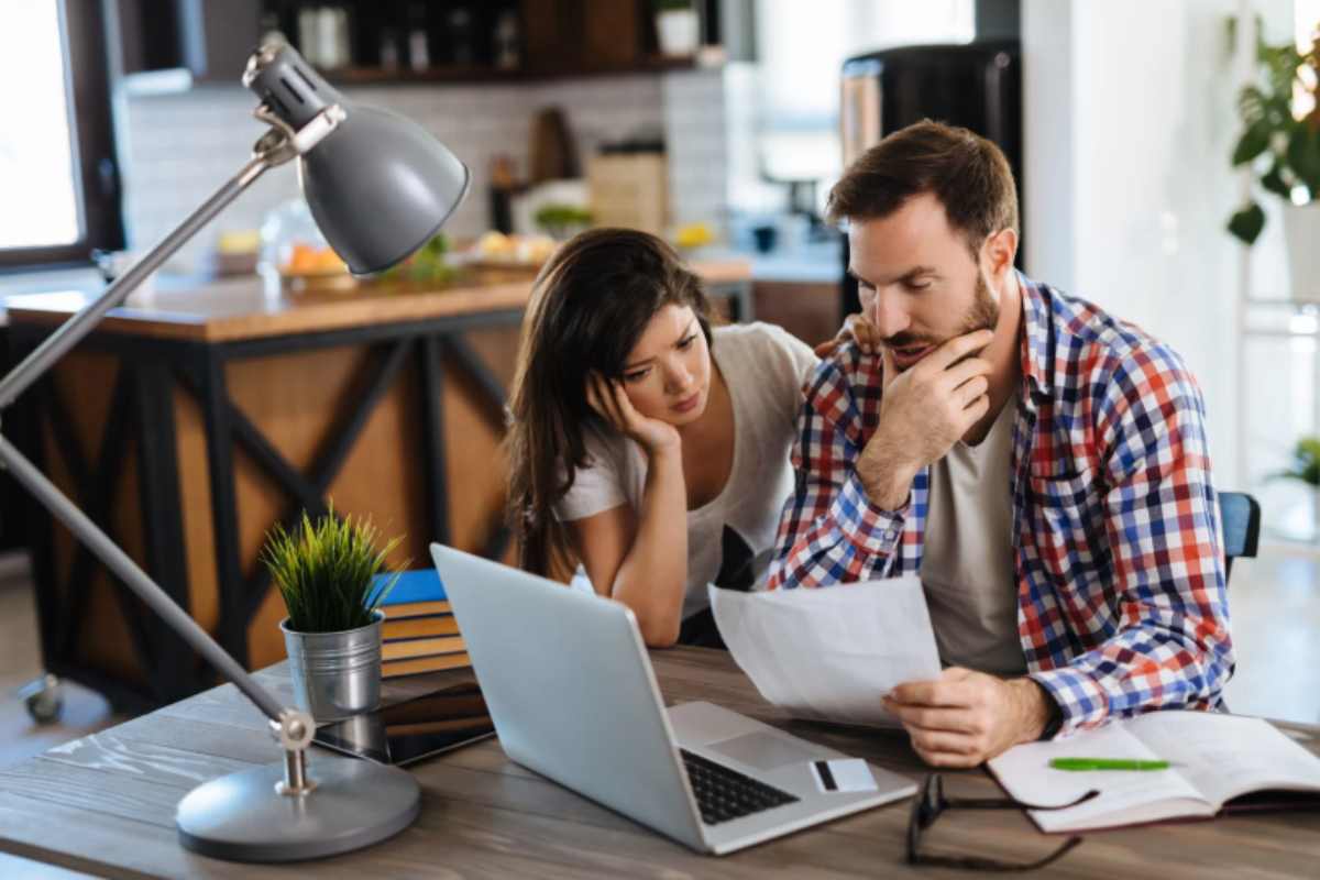 uomo e donna con aria preoccupata mentre leggono dei fogli