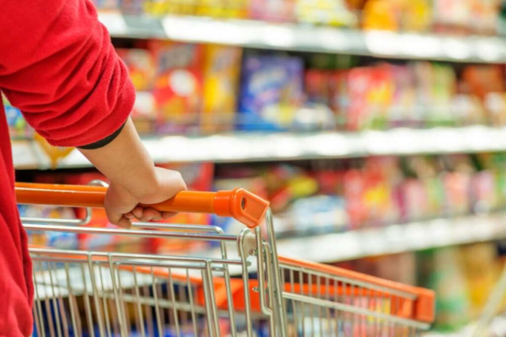 donna che spinge il carrello della spesa al supermercato