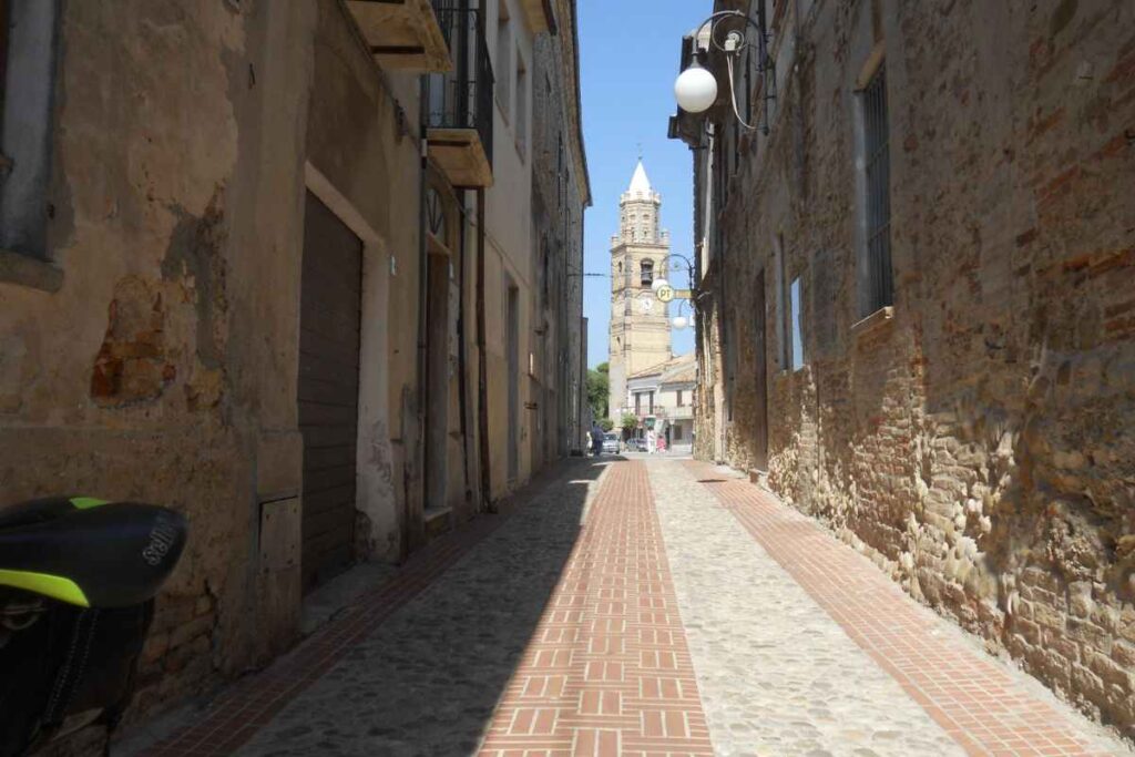 una stradina e una torre in fondo
