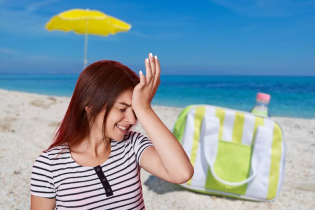 borsa frigo in spiaggia e donna con mano sulla fronte