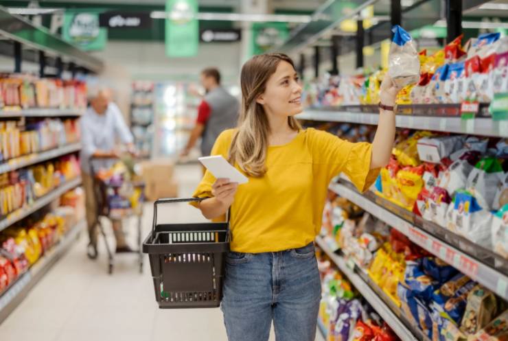 donna che fa la spesa con il cestino al braccio