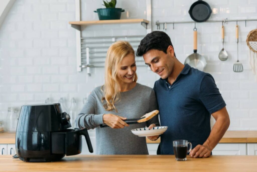 uomo e donna che cucinano con la friggitrice ad aria