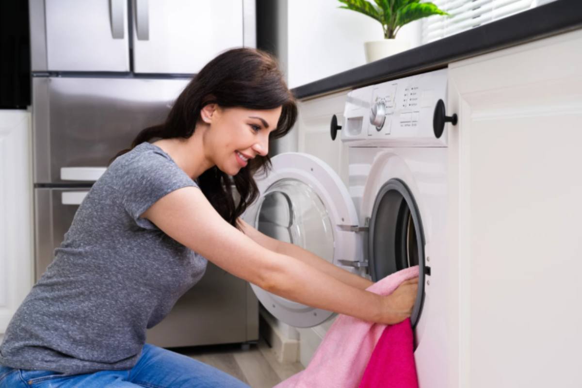 donna che prende i panni dalla lavatrice