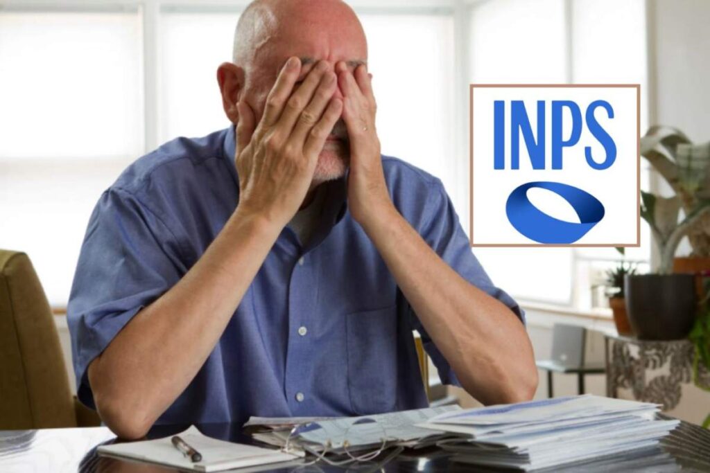 uomo seduto alla scrivania con mani in faccia e logo dell'inps