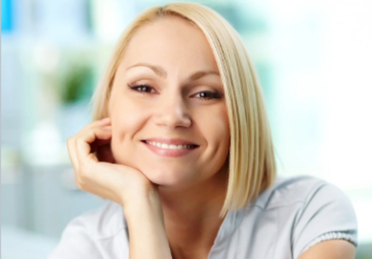 donna che sorride con una mano sotto al mento