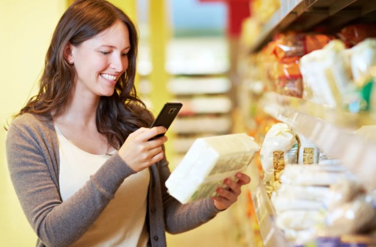 donna che fa la spesa e scansiona il codice di un prodotto con il cellulare