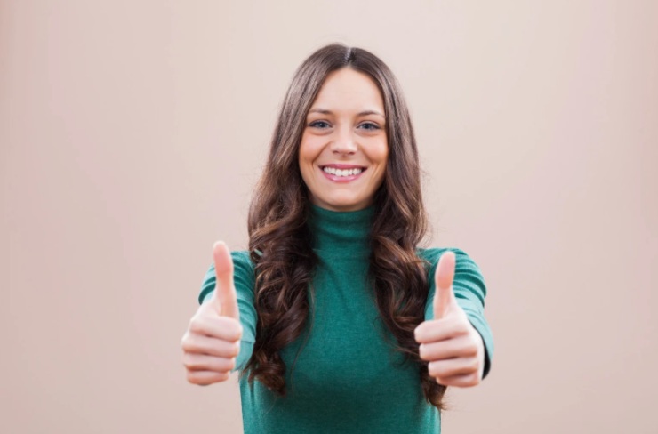 donna che sorride con i pollici in su