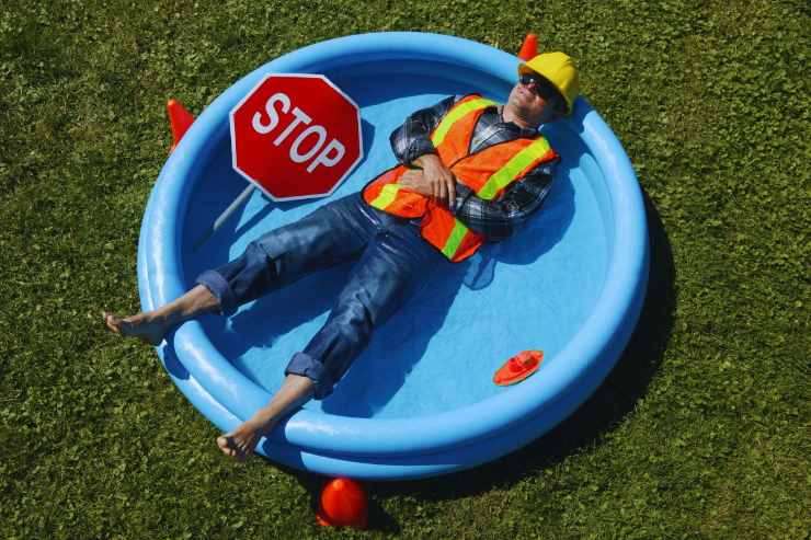 Operaio che si prende un break per il troppo caldo, facendo un bagno in piscina