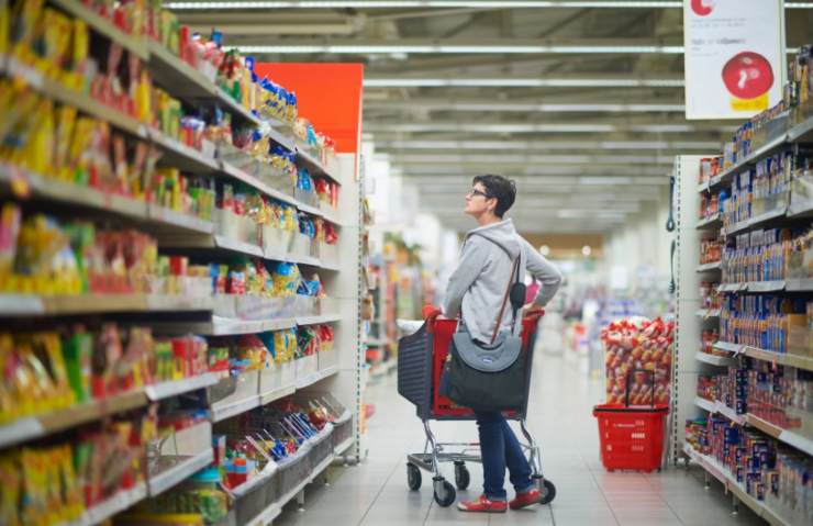 persona con il carrello della spesa in una corsia del supermercato