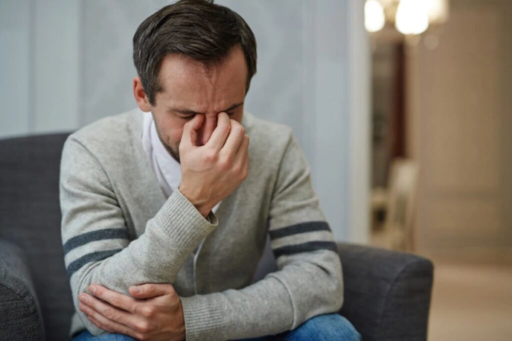 uomo seduto pensieroso con gli occhi chiusi