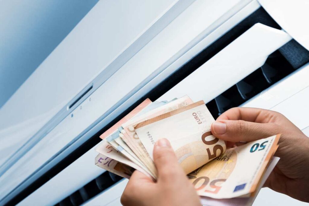 Un condizionatore acceso e dei soldi in euro