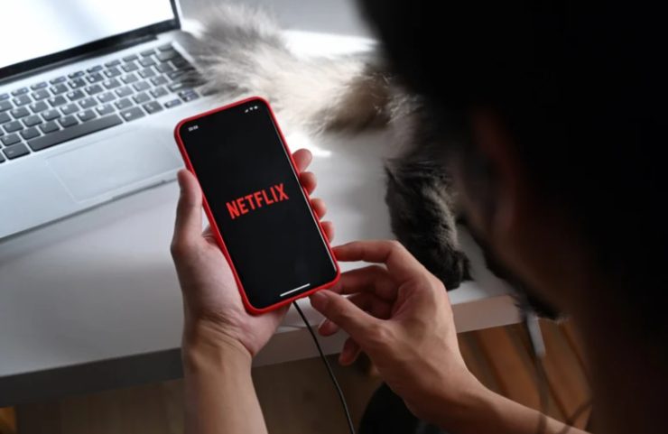 donna con cellulare con logo netflix
