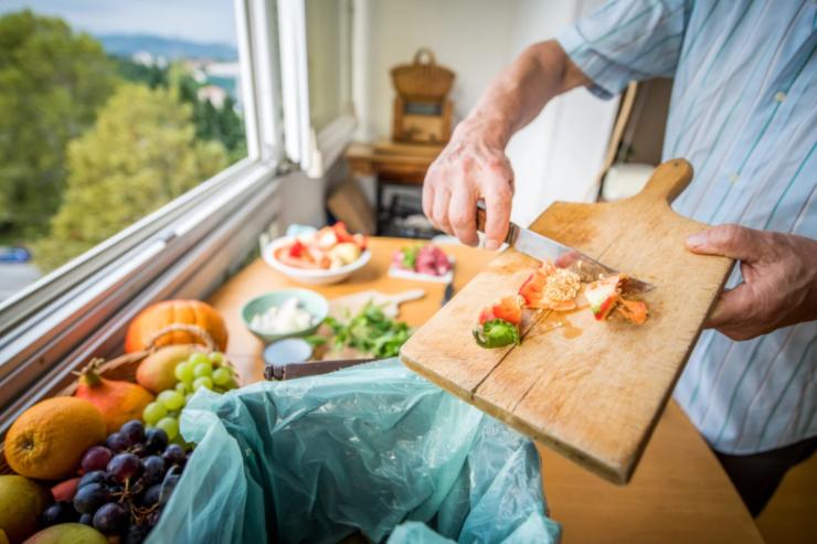 persona che getta via degli scarti di cibo